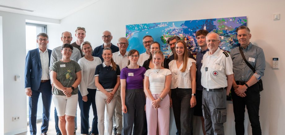 Schnupper-Praktikum auf dem NATURE ONE-Festival begeistert Medizinstudierende v.l.n.r.: Klaus Adams (Vorstandsvorsitzender KSK Rhein-Hunsrück), Volker Boch (Landrat), Dr. Stefanie Bender (Amtsärztin, Leiterin GA Simmern), Carl Gummersbach (Praktikant), Dr. Stephanie Zang (Oberärztin Diakonie Kliniken Hunsrück gGmbH), Guido Scherer (GA), Dr. Louise Brenner (Ärztin in Rheinböllen + Simmern), Dr. Georg Brenner (Arzt in Rheinböllen + Simmern), Lisa Etges (Praktikantin), Dr. Lukas Sabel (Arzt in Oberwesel), Cosima Naffin (Praktikantin), Emma Ihmig (Praktikantin), Axel Strähnz (Arzt in Oberwesel), Laura Gregori (Praktikantin), Edon Rufati (Praktikant), Heinz-Dieter Wieß (Kreisbereitschaftsleiter DRK KV), Dominic Daub (Dezernent KV Rhein-Hunsrück)